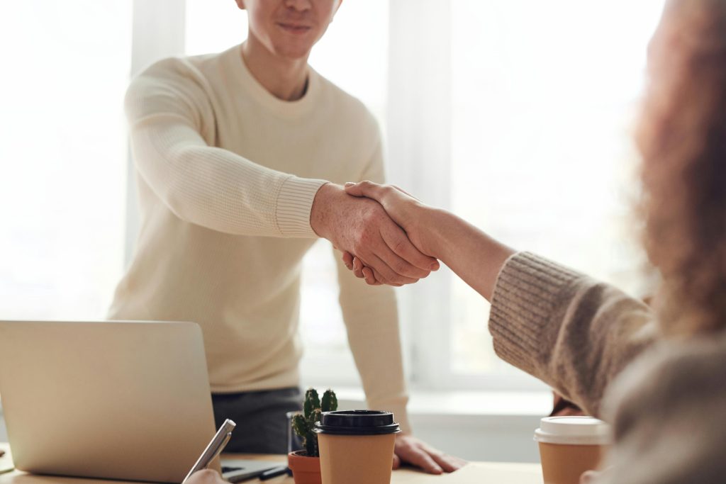 photo de deux personnes qui se serrent la mains au bureau